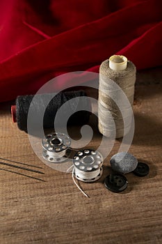 Portrait image of stitching tools on wooden board and red cloth