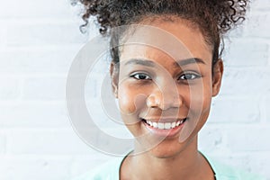 Portrait images of and African American girl, she has curly black hair and a beautiful smile