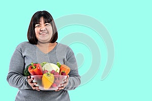 Asian attractive fat woman holding glass bowl  contains fruit and fresh vegetables