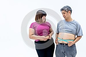 Portrait images of Asian couple, fat man and woman, are looking at each other`s belly fa