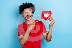 Portrait of impressed astonished person wear red t-shirt directing at like postcard in hand staring isolated on blue