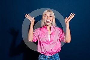 Portrait of impressed girl with bob hairdo wear stylish shirt raising up arms staring at big sale isolated on dark blue