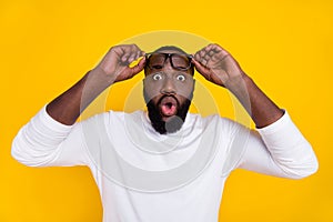 Portrait of impressed person stupor confused hold glasses open mouth isolated on yellow color background