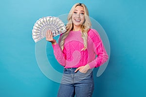 Portrait of impressed woman curly hairstyle knit pullover arm in pocket hold money win lottery staring isolated on blue