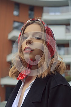 Portrait of an incredibly beautiful girl with blue eyes. Fashionable photo. Trendy style in clothes, a girl in a silk scarf and