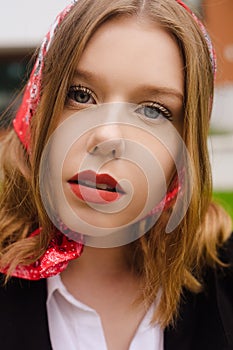 Portrait of an incredibly beautiful girl with blue eyes. Fashionable photo. Trendy style in clothes, a girl in a silk scarf and