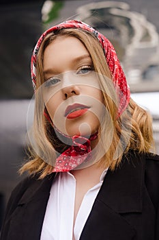 Portrait of an incredibly beautiful girl with blue eyes. Fashionable photo. Trendy style in clothes, a girl in a silk scarf and