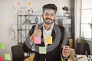 Portrait of indian office manager showing thumb up sign