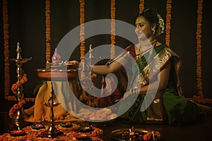 Portrait of Indian Woman celebrating Diwali festival by Lighting the lamp