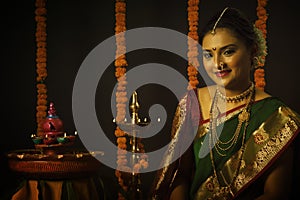 Portrait of Indian Woman celebrating Diwali festival by Lighting the lamp