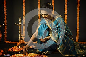 Portrait of Indian Woman celebrating Diwali festival by Lighting the lamp