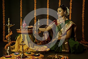 Portrait of Indian Woman celebrating Diwali festival by Lighting the lamp