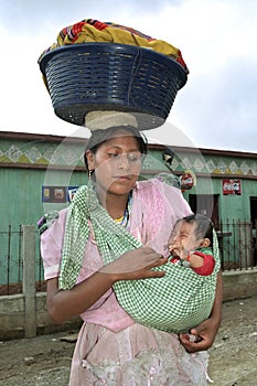 Portrait of Indian woman lugging laundry and baby