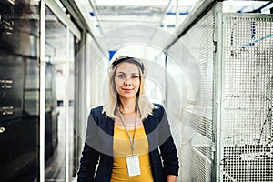 A portrait of an industrial woman engineer standing in a factory.