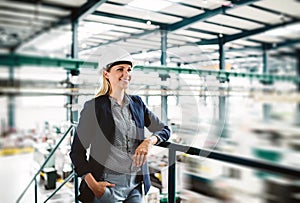 A portrait of an industrial woman engineer standing in a factory.