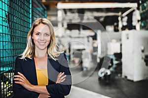 A portrait of an industrial woman engineer standing in a factory. Copy space.