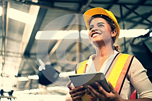 Portrait of industrial worker standing with tablet holding in her hand feeling proud and confident looking for the new opportunity