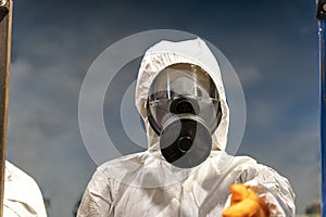 Portrait industrial worker technologist wearing hazmat suit in production plant. Man in white protective uniform with