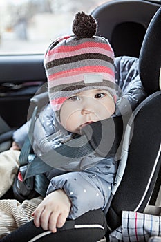 Portrait of infant child sitting in car safety seat, eight month old