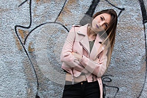 Portrait of informal fashionable girl on graffiti wall background