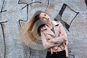 Portrait of informal fashionable girl on graffiti wall background