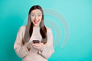 Portrait of inpressed funky teen blogger use her cell phone got news from social account wear knitted woolen jumper