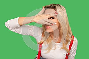 Portrait of inquisitive nosy adult woman spying, looking through fingers with prying eyes, scared and shy to watch photo