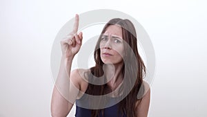 Portrait of instructive woman. Finger up. Frown. Instructive gesture.