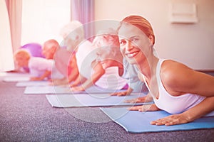 Portrait of instructor performing yoga with seniors