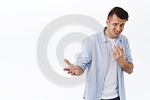 Portrait of insulted and shocked caucasian guy being accused in something, pointing at himself offended and frustrated