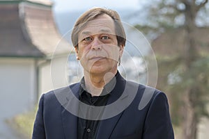 Portrait of an intelligent, self-confident elderly man of 50 years, an entrepreneur in a suit against the background