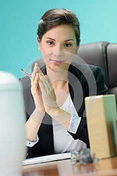 Portrait intelligent serene businesswoman sat at desk