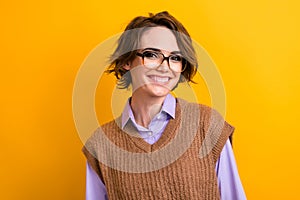 Portrait of intelligent woman with bob hairdo wear knit waistcoat in glasses smiling at camera isolated on yellow color