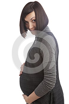 Portrait of Intriguing Smiling Cute Positive Caucasian Brunette Pregnant Woman in Grey Dress Posing Over Pure White Background