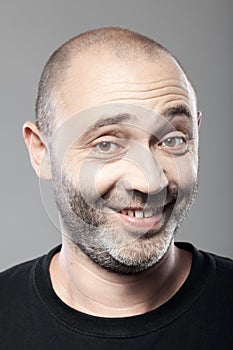 Portrait of ironical smiling man isolated on gray