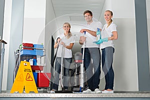 Portrait Of Janitors Holding Cleaning Equipments