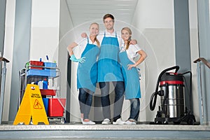 Portrait Of Janitors Holding Cleaning Equipments