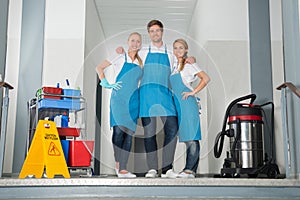 Portrait Of Janitors Holding Cleaning Equipments photo