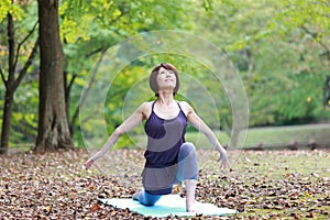 Portrait of Japanese woman doing yoga exercise outdoor