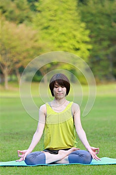 Portrait of Japanese woman meditating outdoor