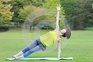 Portrait of Japanewe woman doing yoga Side Plank Pose