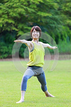 Portrait of Japanewe woman doing yoga warrior II pose