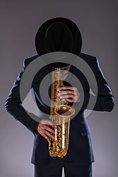 Portrait of a jazz man in a suit with a hat hiding