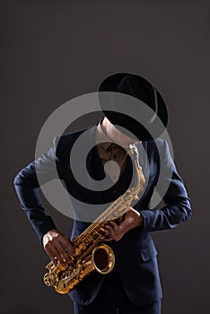 Portrait of a jazz man in a suit with a hat hiding