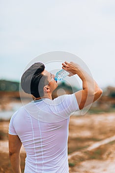 Portrait of jogger drinking water from bottle