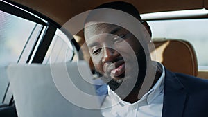 Portrait of joyful african business man reading documents at car. Smiling man