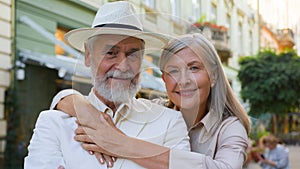 Portrait joyful aged Caucasian happy family elderly wide smiling pensioners woman hugging embrace man looking at camera