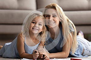 Portrait of blonde two female generations family lying on carpet.