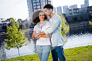 Portrait of joyful family smiling couple young beautiful lovers hugs outdoors spending time together on local river and