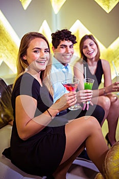 Portrait of joyful friends sitting in nightclub